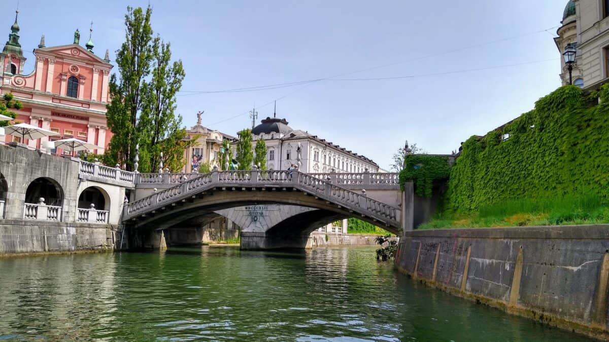 Das Bild zeigt die berühmten drei Brücken, aufgenommen von einem Boot auf der Ljubljanica